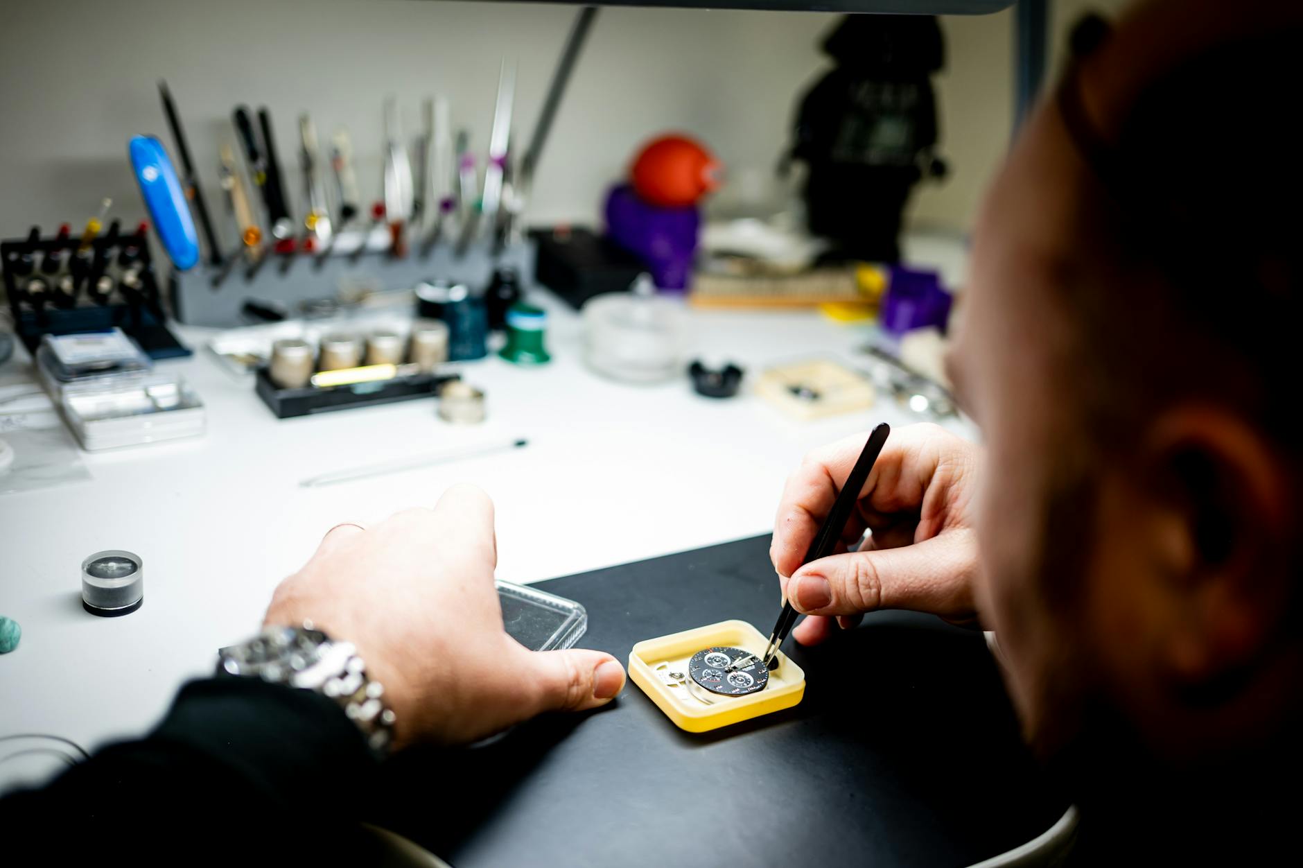 Zegarmistrz naprawia mechanizm zegarka przy profesjonalnym stanowisku