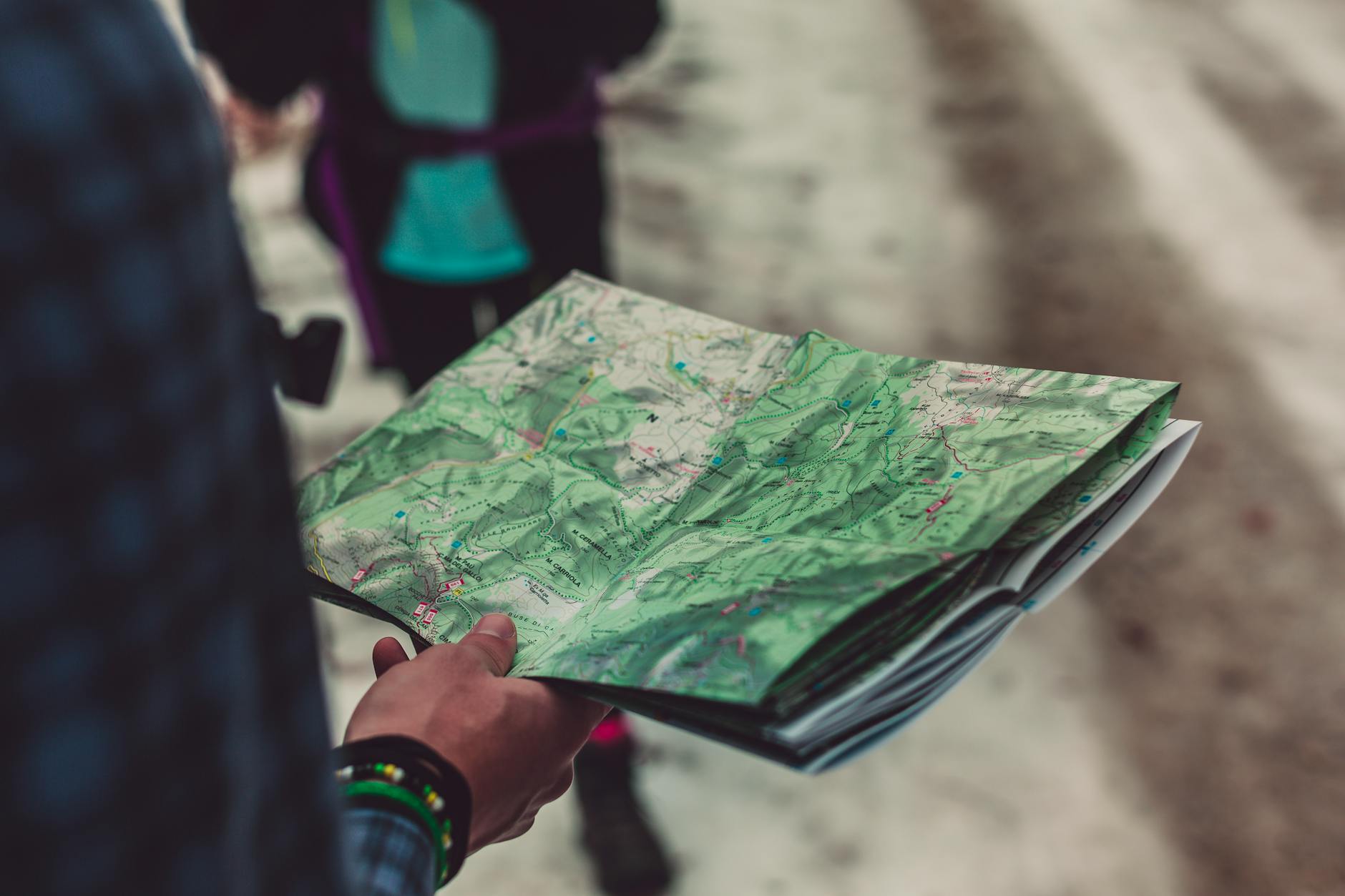 Dłoń podróżnika trzymająca szczegółową papierową mapę trasy