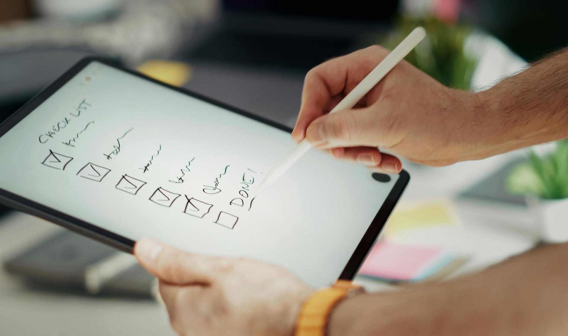 Dłoń zapisująca checklistę ślubną rysikiem na tablecie
