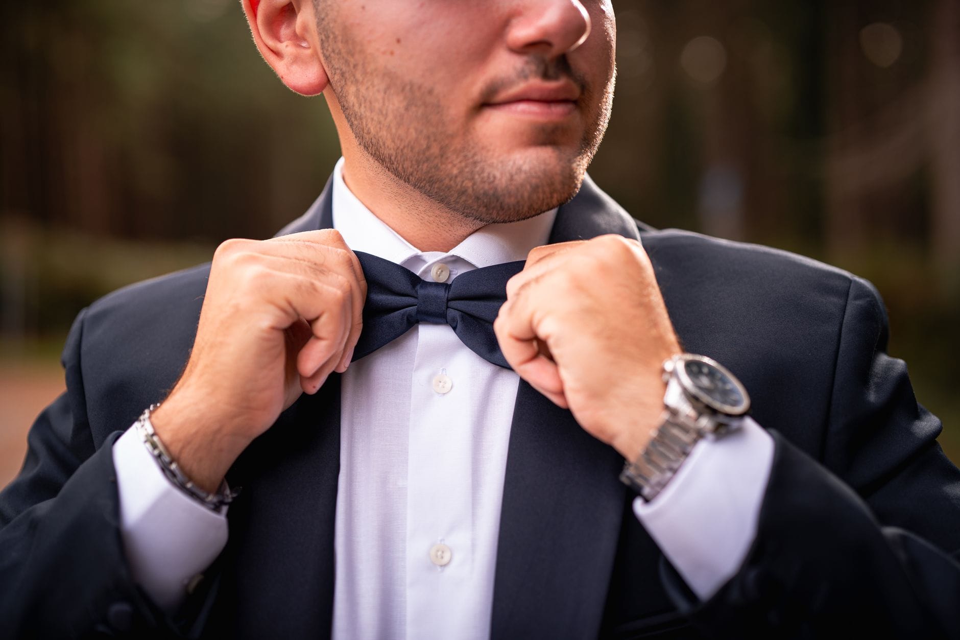 Mężczyzna w smokingu poprawia muszkę na eleganckie wyjście