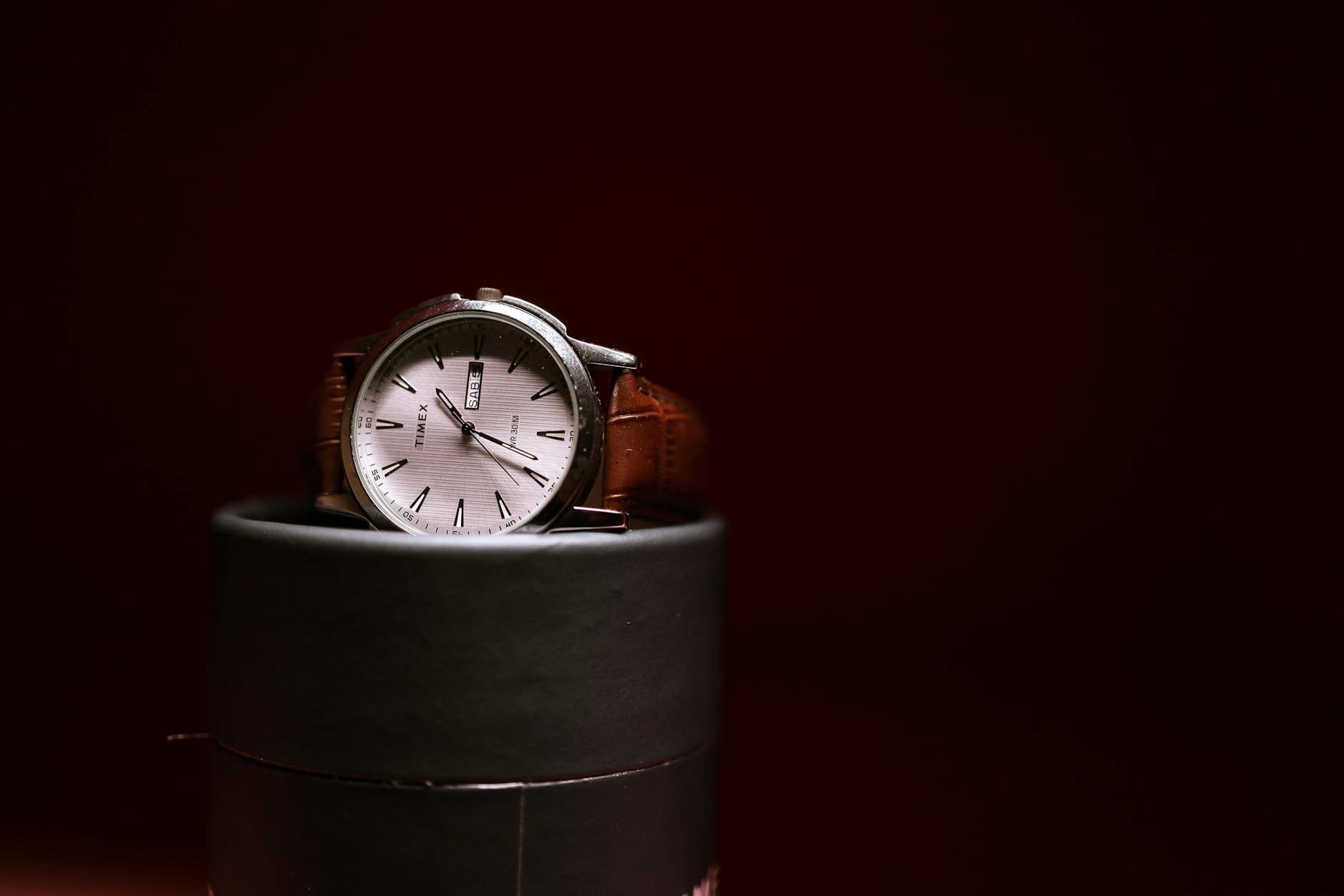 Najlepsze zegarki na prezent do 1000 zł: jakość, która się opłaca Elegancki zegarek Timex na brązowym skórzanym pasku na cylindrycznej podstawce