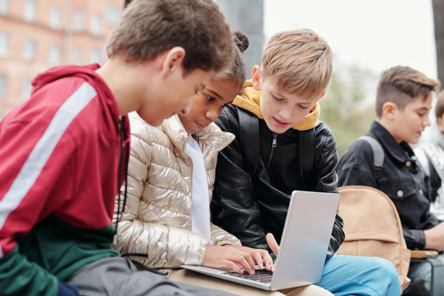 Nastolatki uczą się razem przy laptopie na zewnątrz Nastolatki uczą się razem przy laptopie na zewnątrz