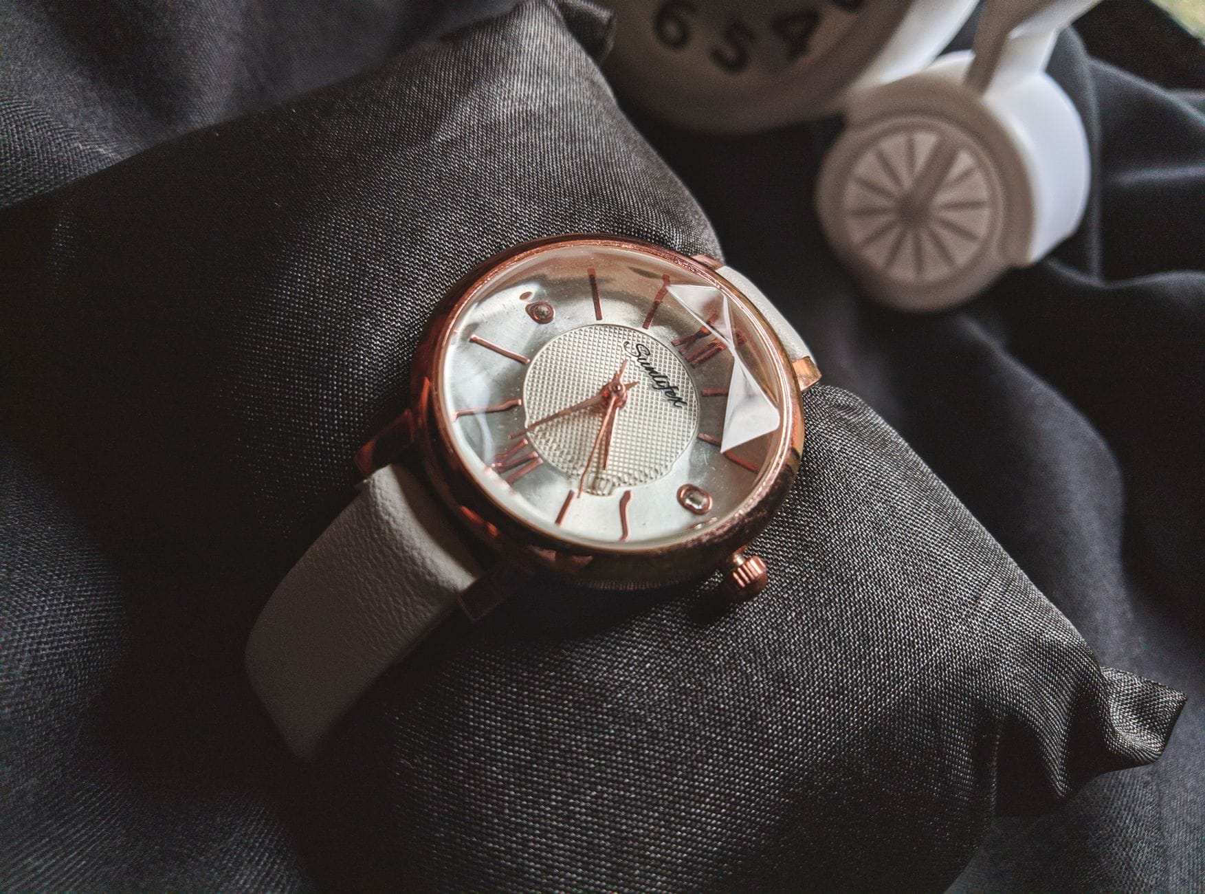 Zbliżenie eleganckiego zegarka w kolorze różowego złota na czarnej poduszce