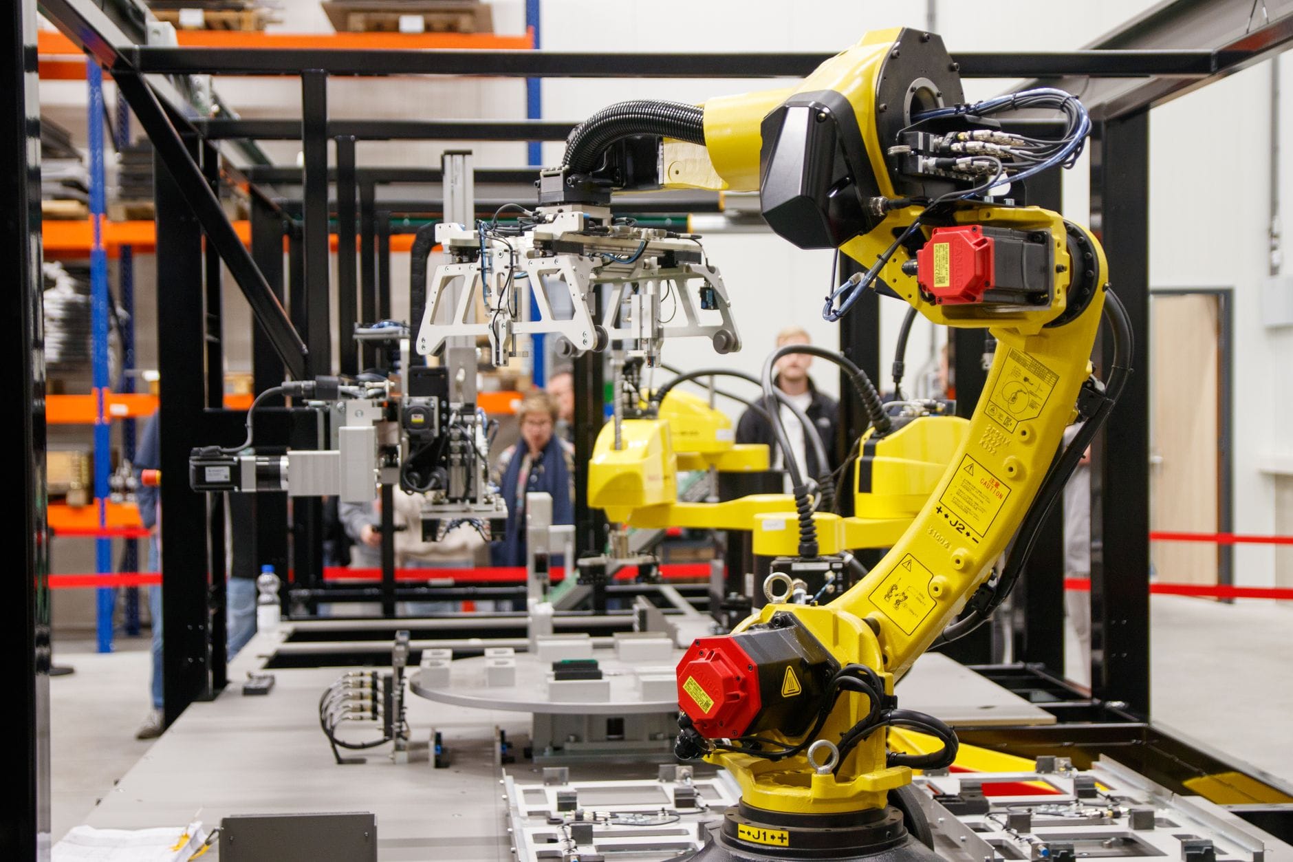 Żółte ramię robota przemysłowego pracujące w nowoczesnej fabryce Żółte ramię robota przemysłowego pracujące w nowoczesnej fabryce