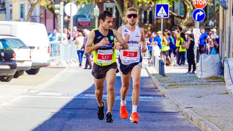 Dwóch biegaczy rywalizujących w miejskim maratonie w słoneczny dzień